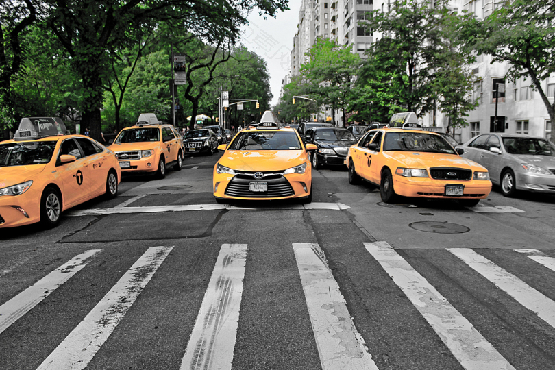 灰色路上的四辆黄色小汽车