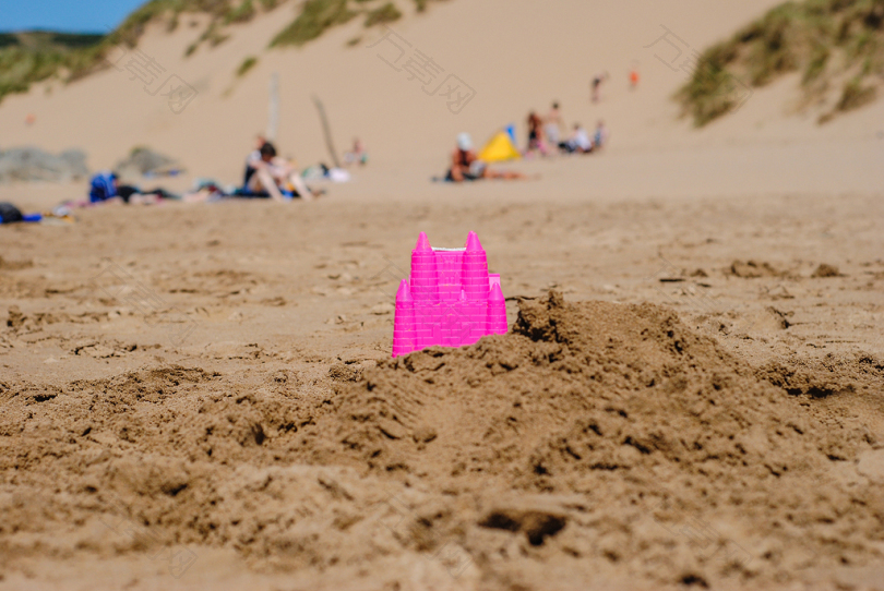 白天在岸边的粉红色城堡玩具