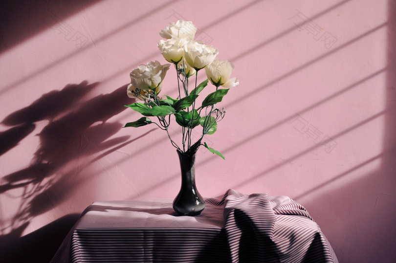 黑色花瓶中的白色假花