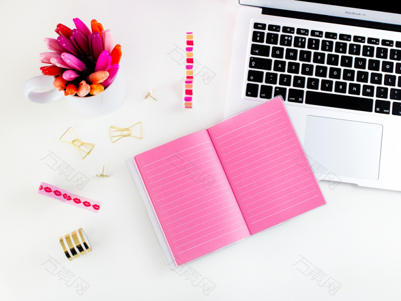 粉红笔记本笔记本旁边的MacBookAir