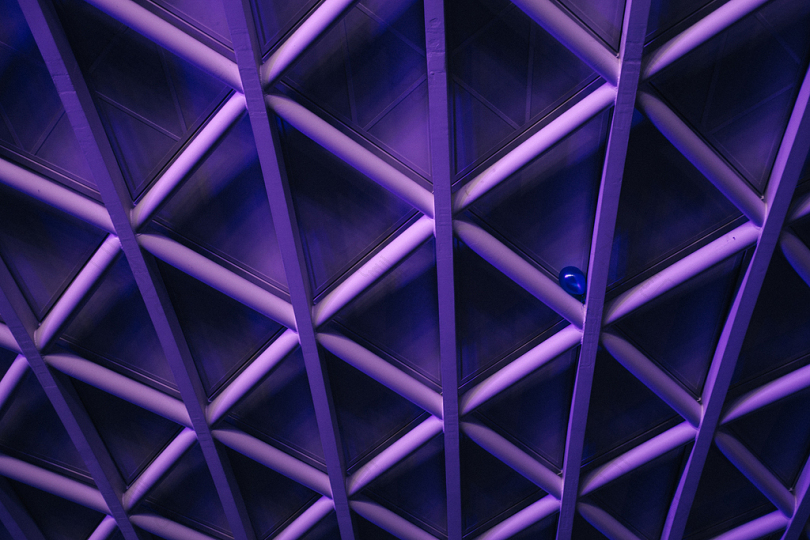 一个十字交叉图案的紫色天花板一个蓝色的气球卡在角落里的一个横杆上