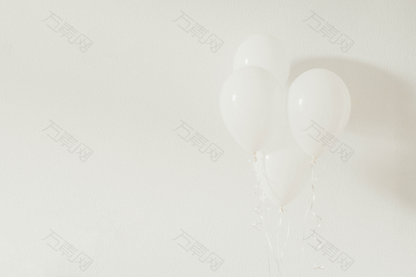 白色墙壁上的四个白色气球