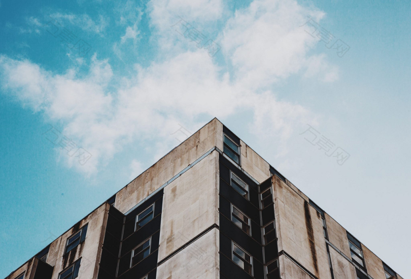 晴空蓝天米色与黑色混凝土建筑的低角度摄影