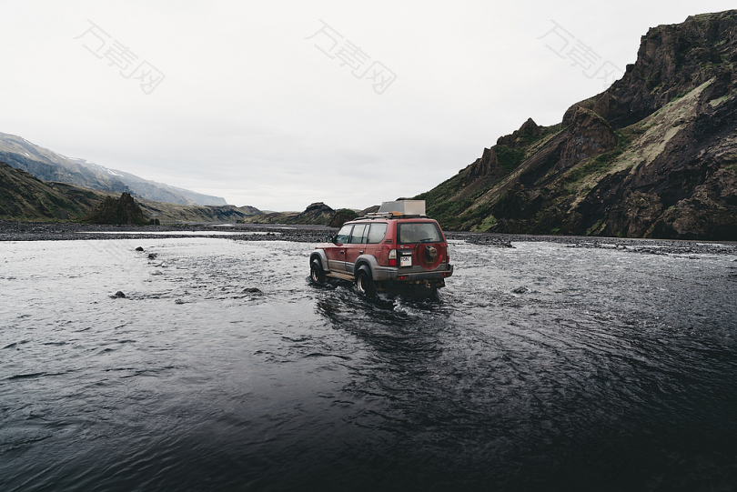 白天在山区附近的水上红色SUV
