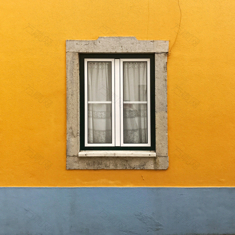 白色窗玻璃对黄墙的照片