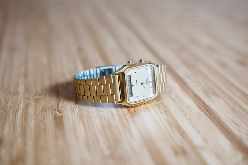 棕色木板上的方形金色模拟手表