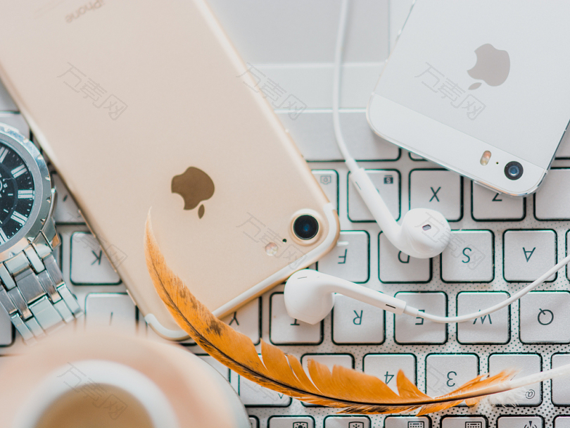 金iPhone7旁边的白色苹果耳坠和银色iPhone5S