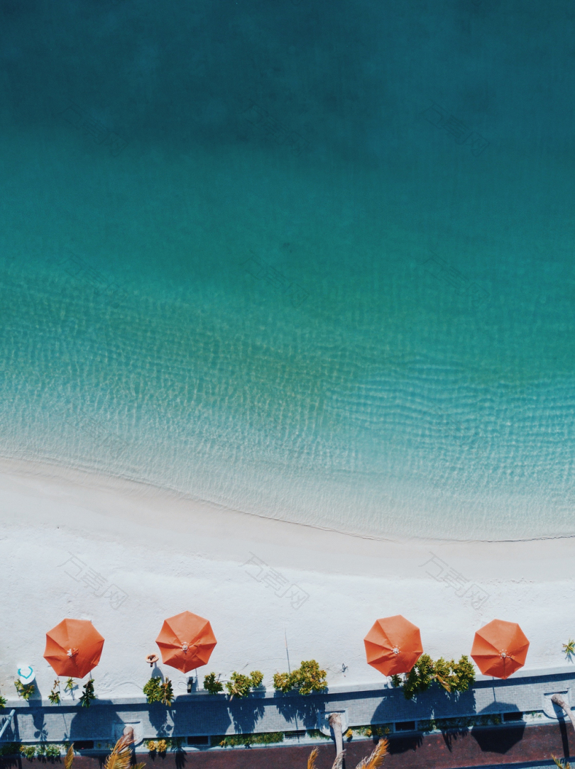 海岸上四张橙色天井雨伞的航空摄影