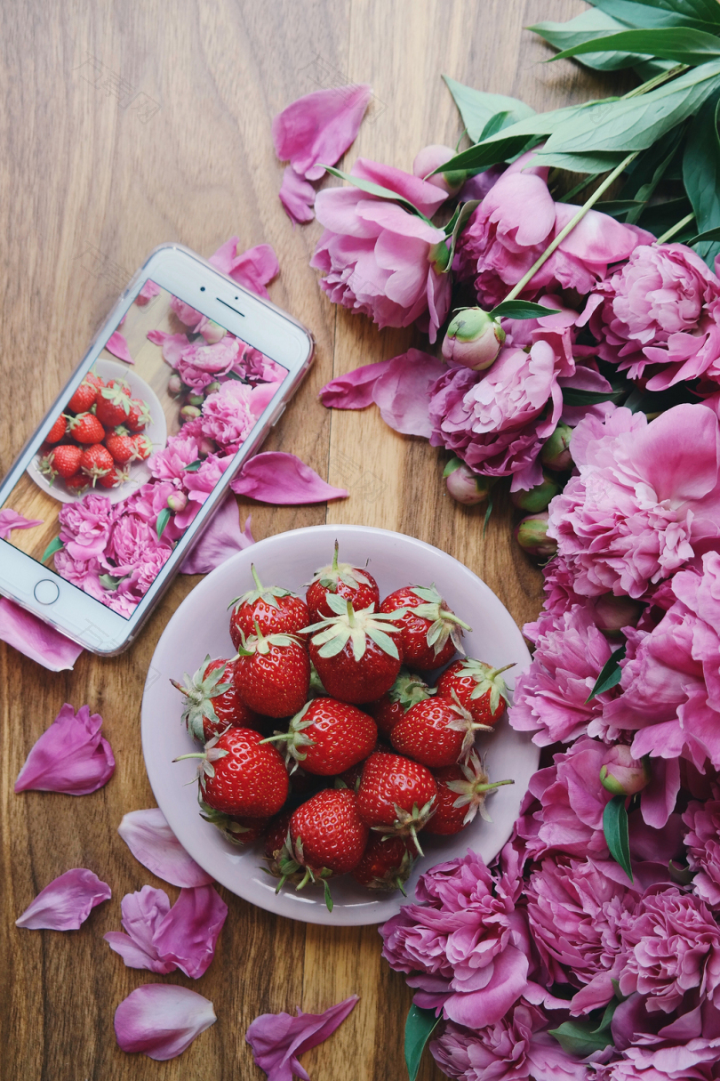 草莓夏天食物水果粉红色牡丹粉红牡丹花平铺木头桌子电话