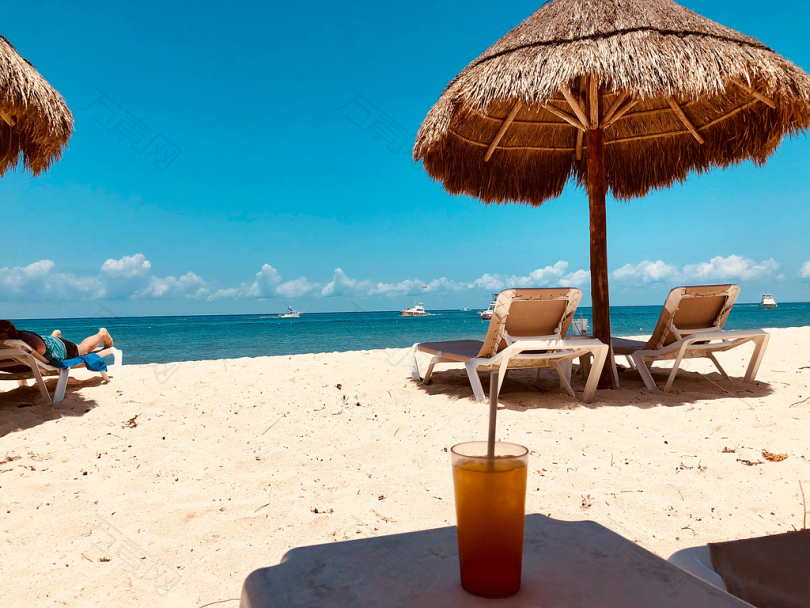 沙滩上的棕色阳伞和两张沙滩椅