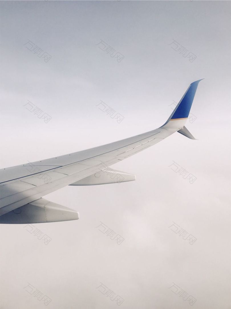 白天白色和蓝色的飞机在云层上飞行