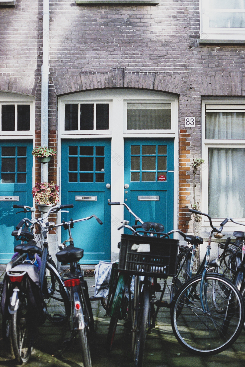 棕色混凝土建筑前的彩色自行车