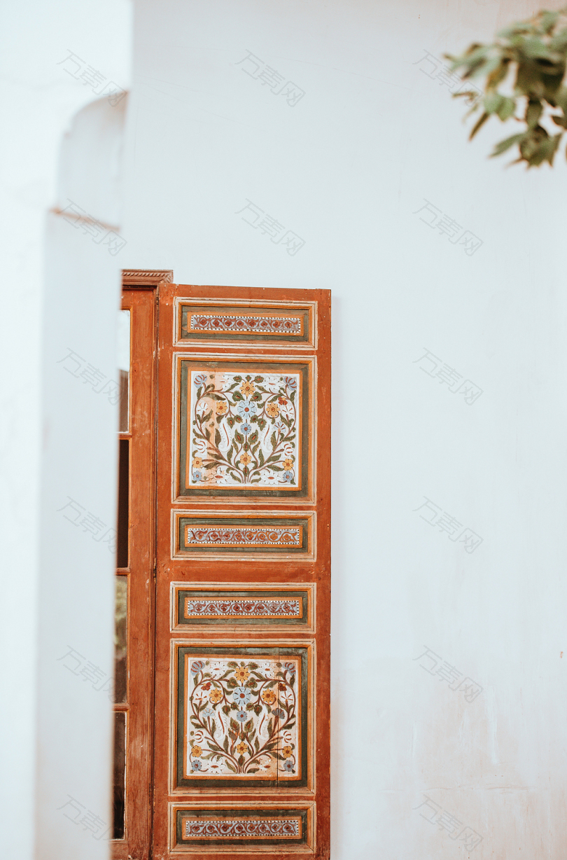 白色墙壁上的棕色和白色花木制橱柜