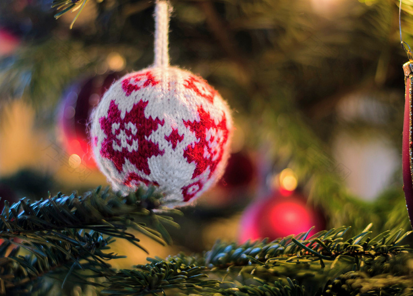 绿色圣诞树上的白色和红色编织的小玩意儿