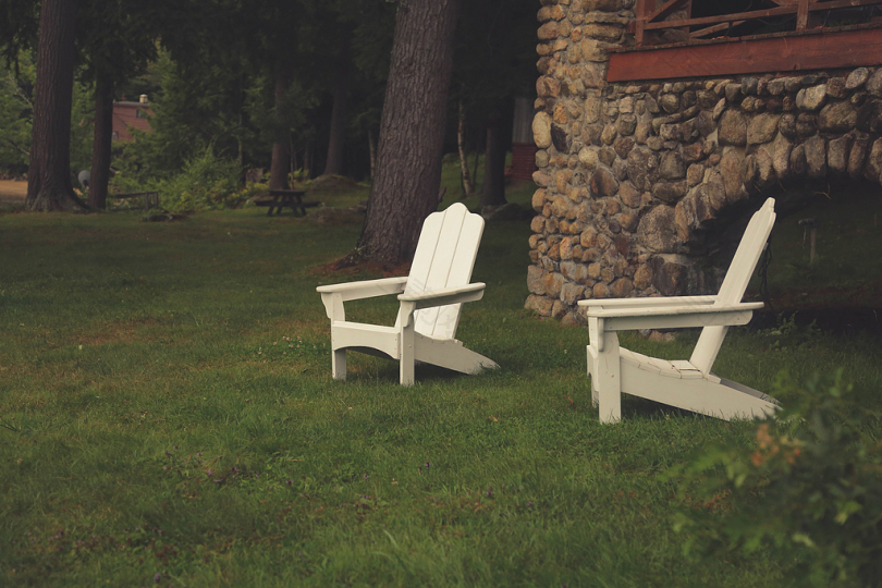 草地上的两张白色木扶手椅