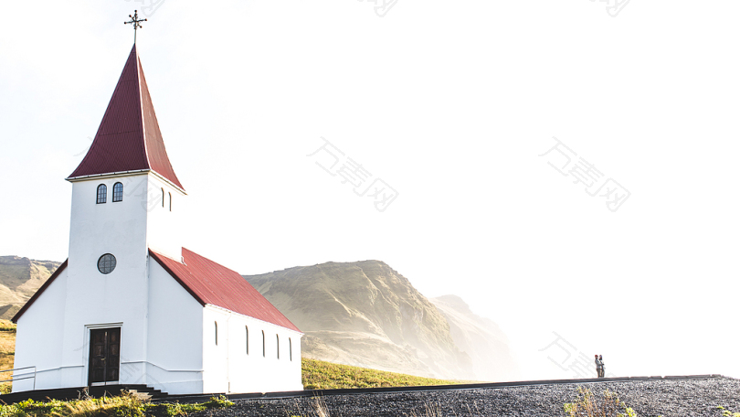 阴天下灰山附近的红白混凝土教堂