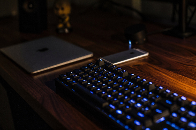 棕色办公桌上的黑色电脑键盘