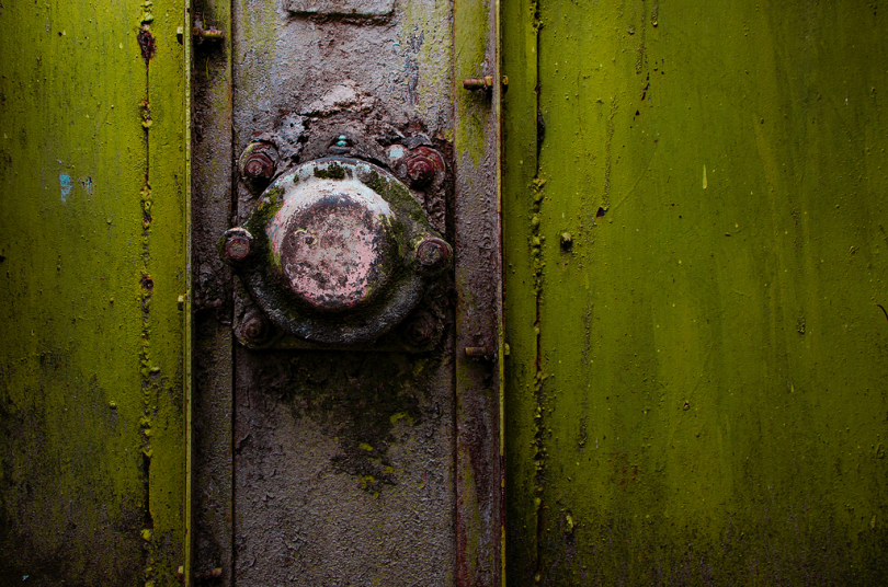 一个生锈的金属把手在一个绿色保险箱上的特写镜头