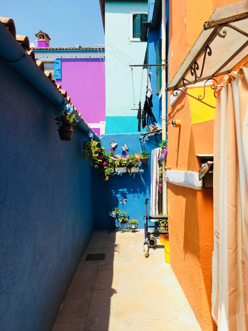 蓝色和橙色墙壁之间的小巷