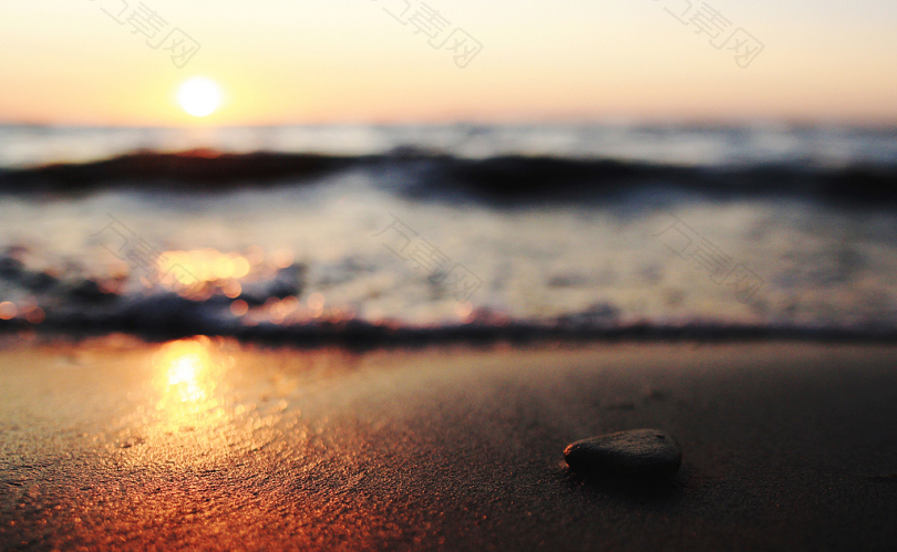 日落时海岸上卵石的选择性聚焦摄影