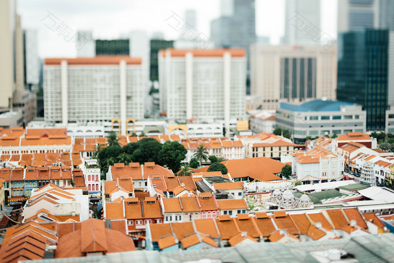 白昼和橙色房屋在高层建筑周围的倾斜摄影