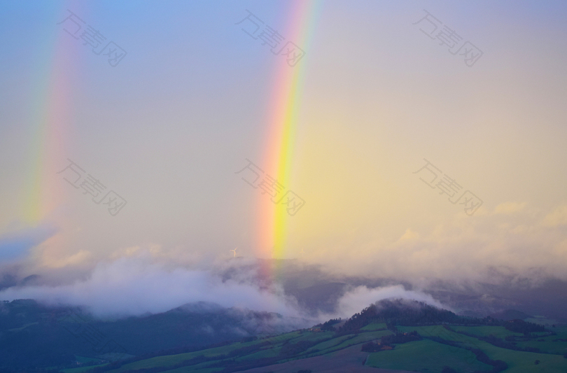 布满雾霭的棕色山上的彩虹
