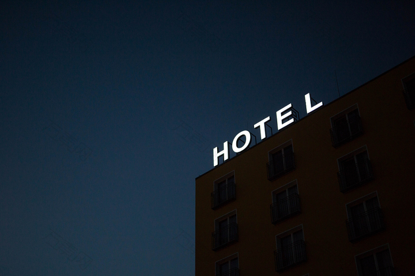 夜间在棕色建筑顶部的酒店照明标志的低角度照片