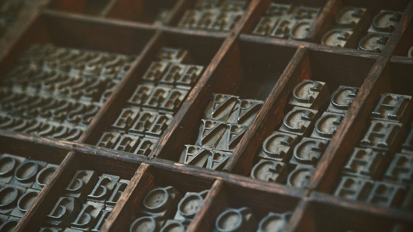 棕色木制组织者盒中的灰色相配字母首饰