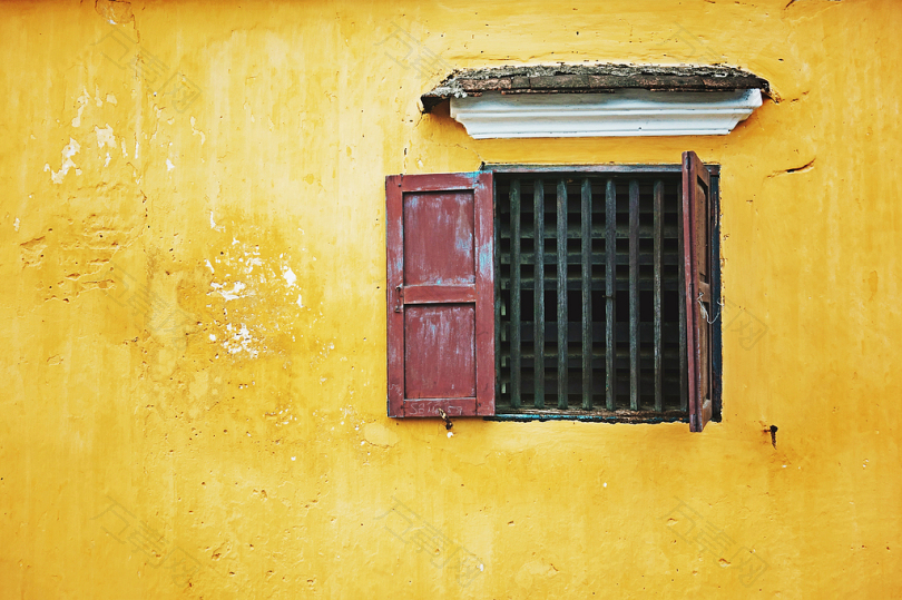 黄色墙壁上的木窗户