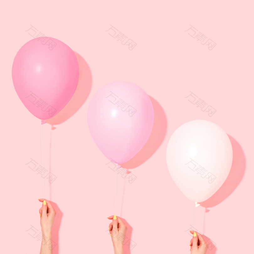 手持粉红色和白色气球的人