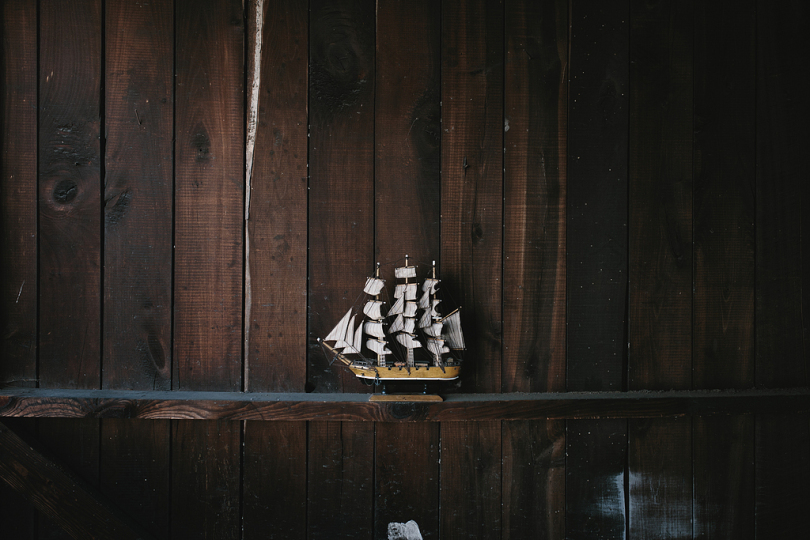 棕色褐木架上的黑色棕色和白色帆船模型