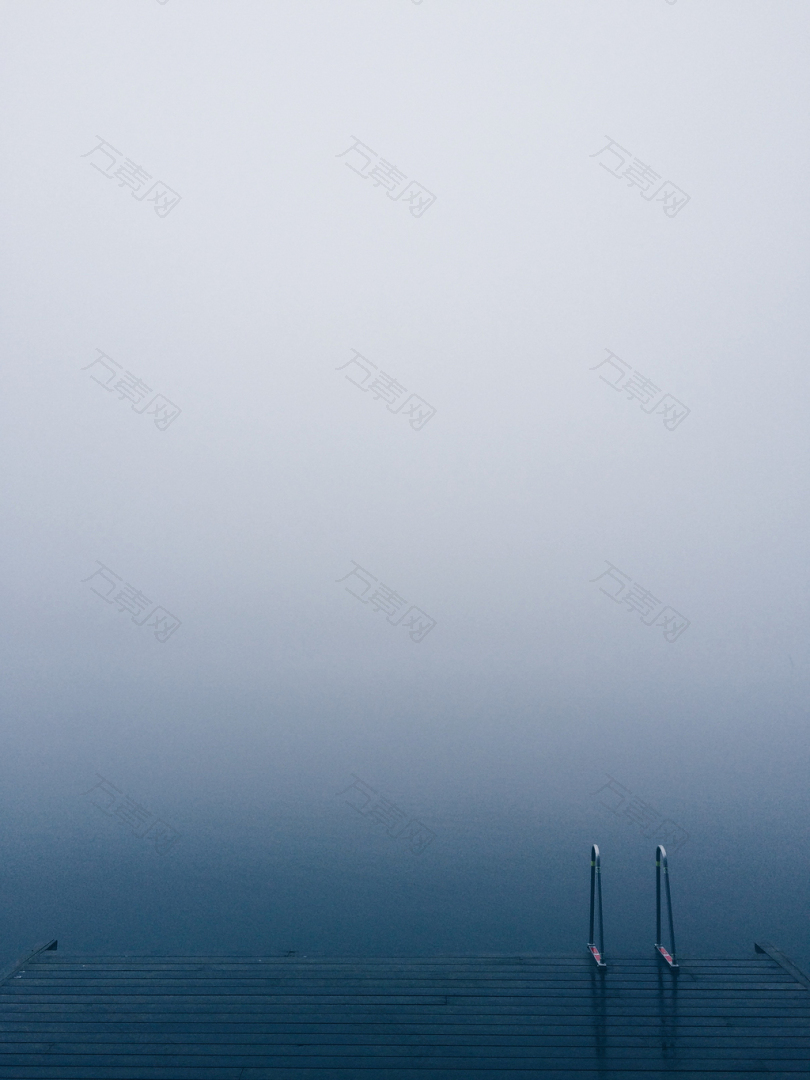 雾天平静的湖边有梯子的湖码头