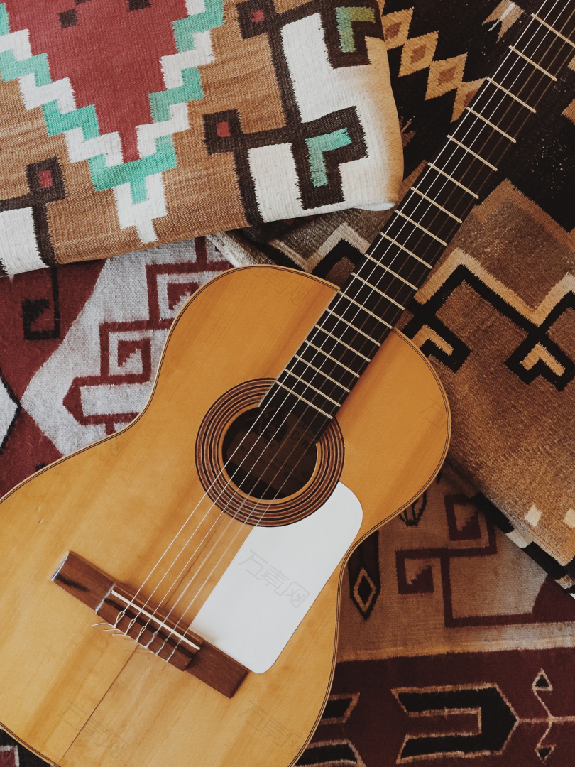 棕色纺织品上的棕色原声吉他
