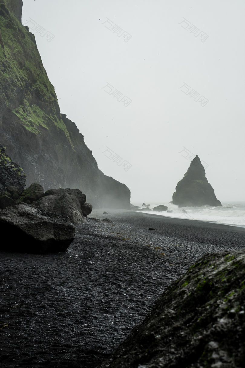 滨海水域水体黑色岩层景观照片