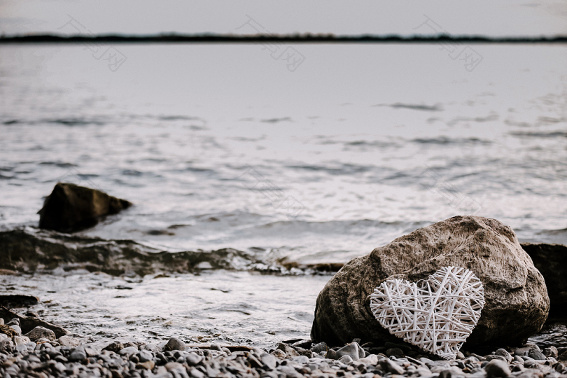 靠近海岸线的棕色岩石上的心形弦乐作品
