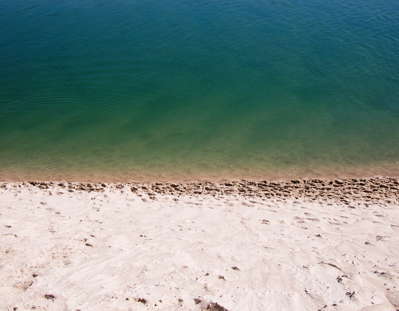白沙在白天绿色平静的水体