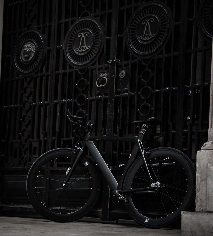 黑色钢闸门上的黑色固定齿轮自行车