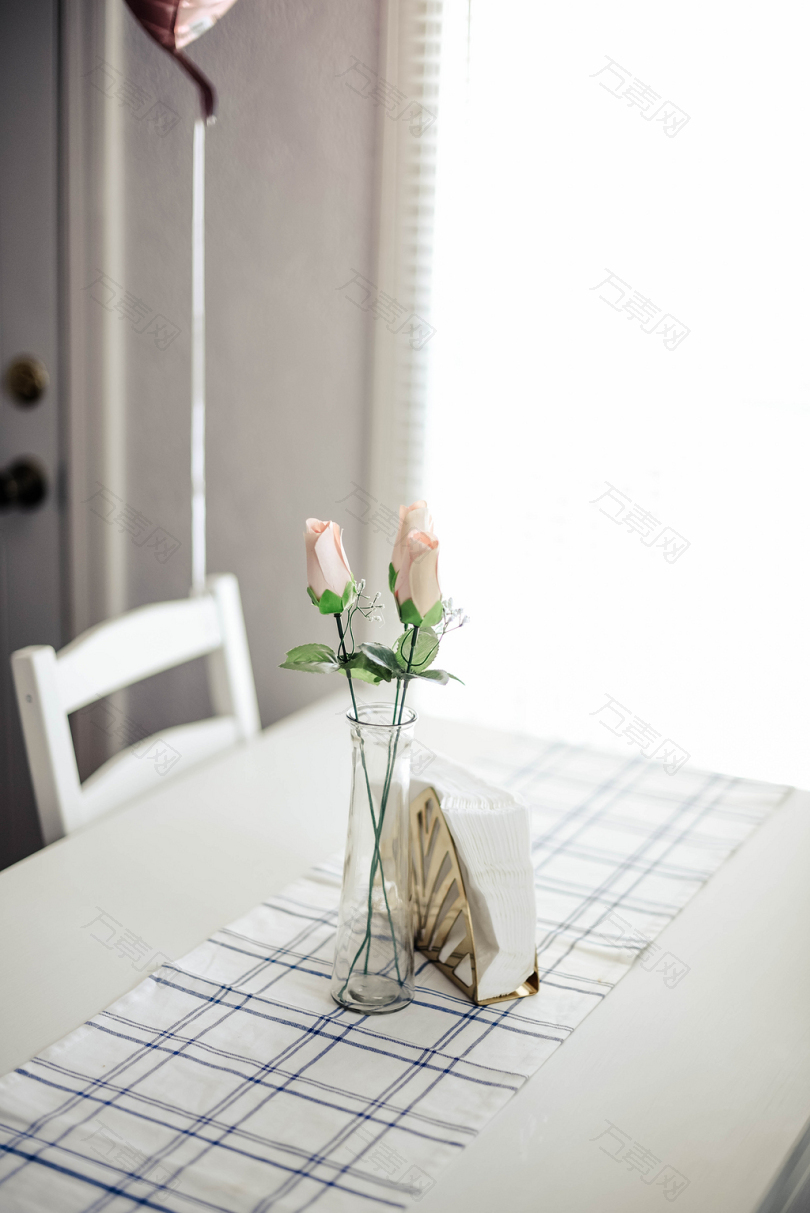 餐桌上的玻璃花瓶里的粉红玫瑰
