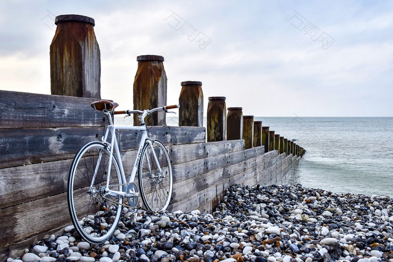 棕色木制码头旁的白色自行车