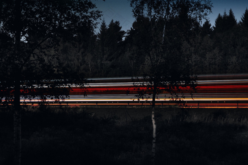 夜间车辆在树间行驶时的时间推移摄影