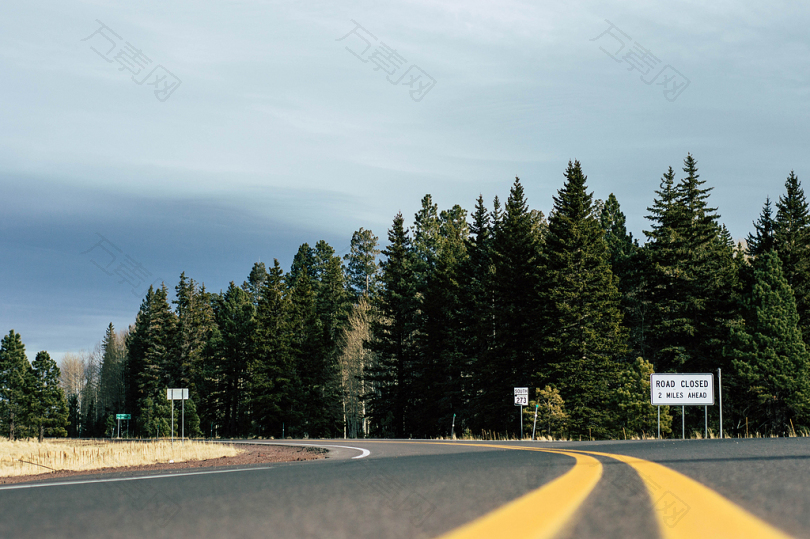 倾斜的黑色低空道路向远方转弯的低角度照片