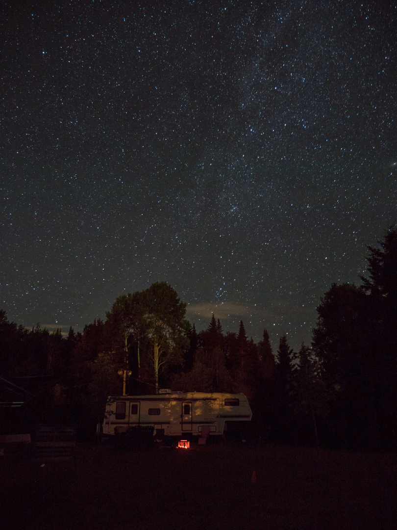 夜间树木环绕的白色RV拖车