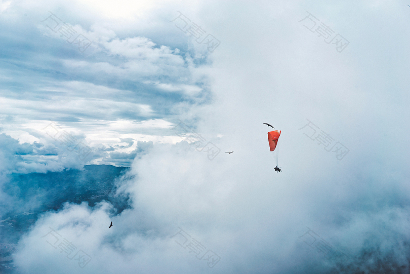 云层环绕的人滑翔伞