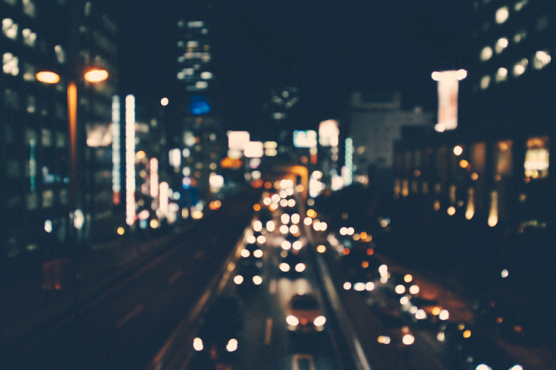 一个城市街道的模糊拍摄在夜间被建筑物和汽车照亮