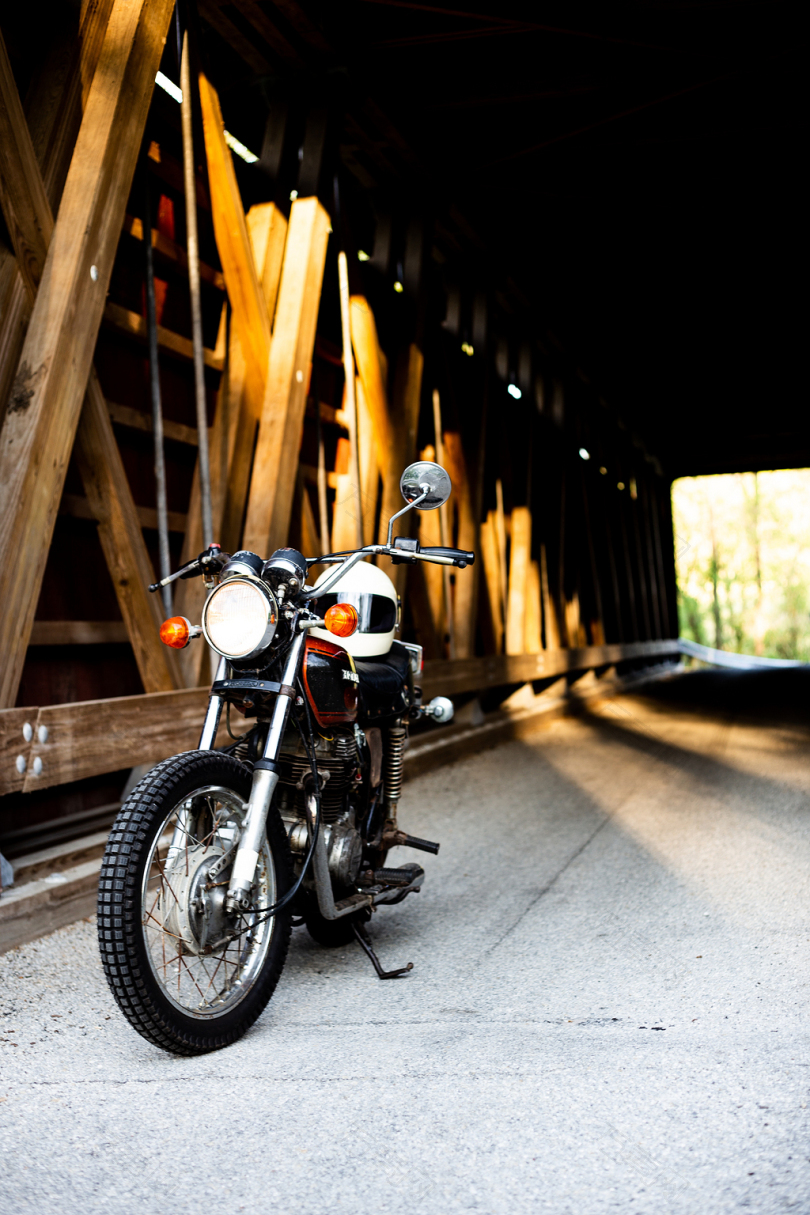 黑色摩托车靠近棕色木桥隧道