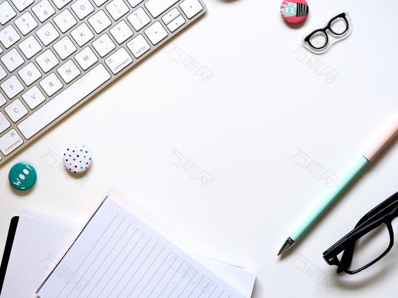 键盘旁边的白纸蓝色笔和眼镜