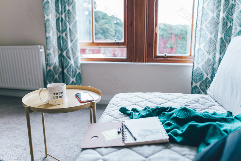 内层圆形黄端桌旁有螺旋式笔记本和绿色舒适床垫的绗缝白床垫
