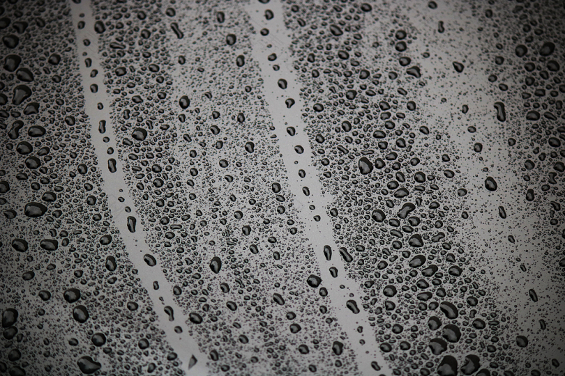 滴湿一滴水雨水金属油漆黑色光漆的潮湿清洗清洁