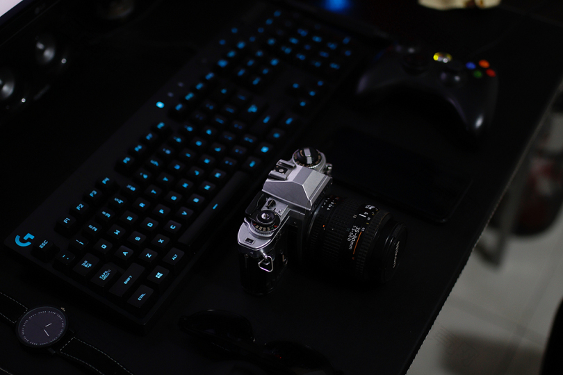 SLR相机GAMEPAD和桌面上的键盘的浅对焦摄影