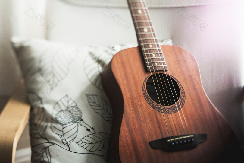 白色枕头上的棕色吉他的选择性聚焦照片